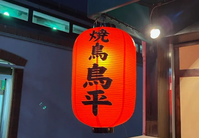 設置事例No.69 焼き鳥店様の店舗看板用17号長型ビニール提灯使用風景夜間ライトアップ時